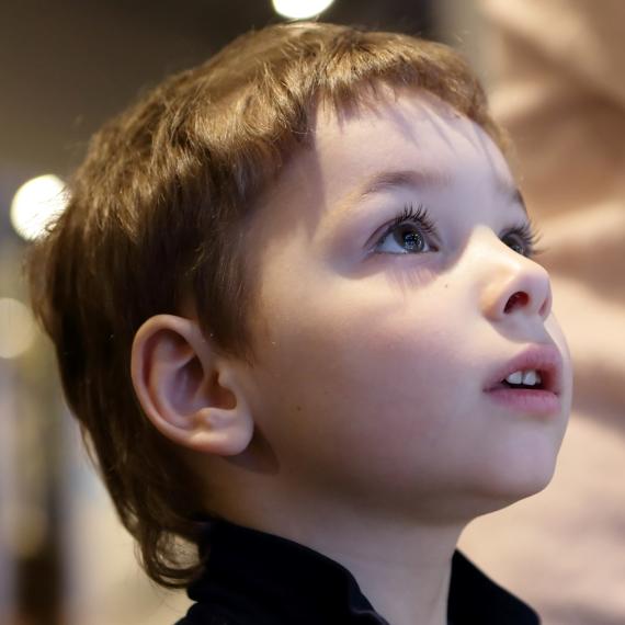 A young child looking away from the camera at a display