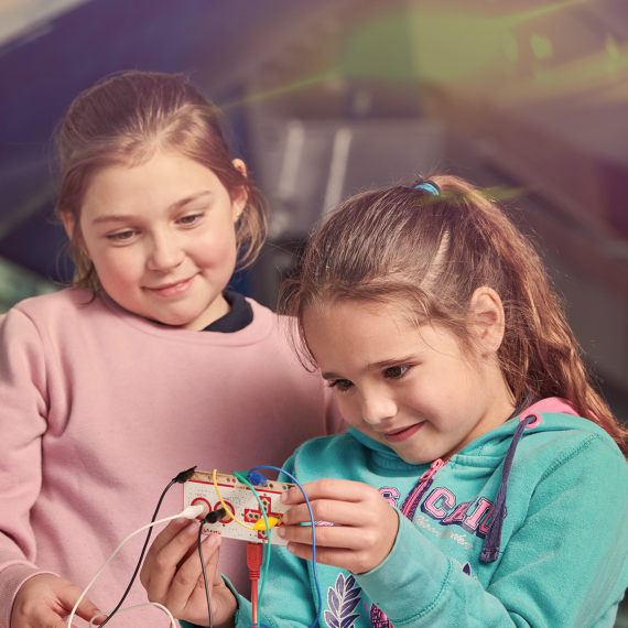Two girls looking at wiring