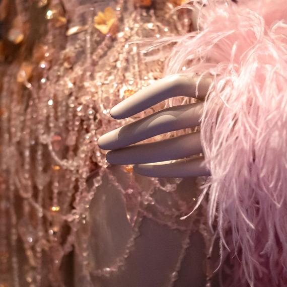 A close-up view of part of a costume covered in beads, sequins and feathers