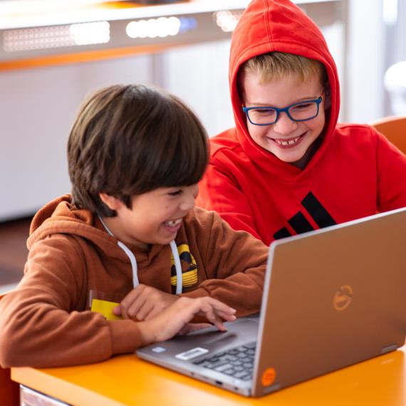 Two boys playing on a laptop