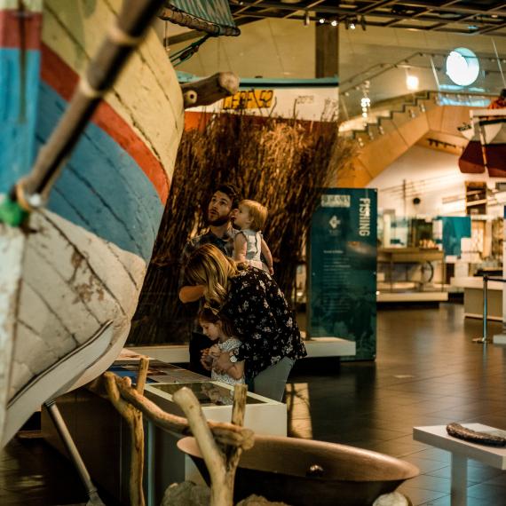 Family exploring museum wooden boat