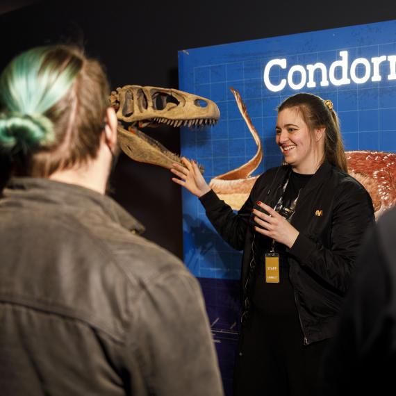 Image of a WAM Boola Bardip staff member taking visitors through the Dinosaurs of Patagonia exhibition.