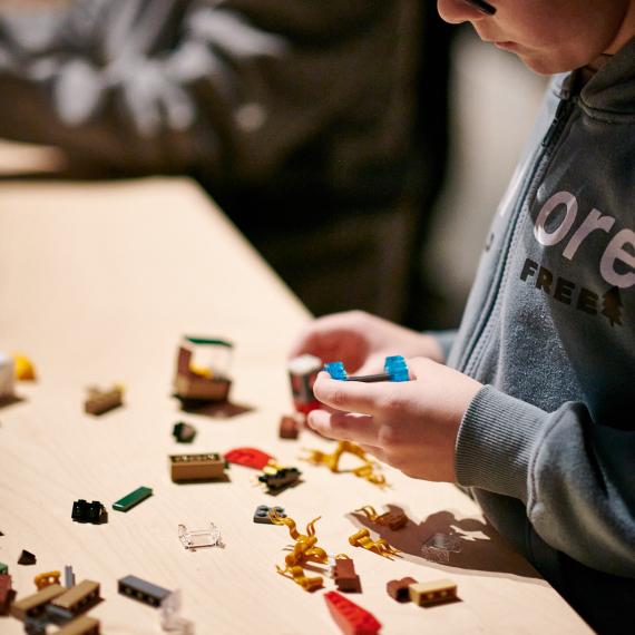 Image of child building LEGO ship using LEGO bricks 