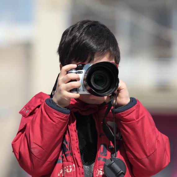 Young photographer taking a photo with a DSLR camera