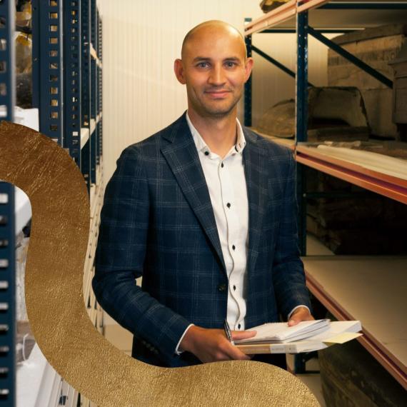 Image of curator standing face on to camerea with paper in his hand