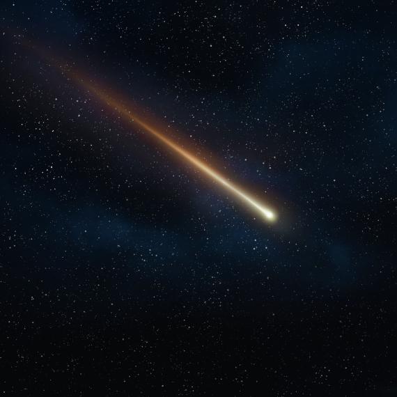 A  fiery meteorite flies through the sky against the backdrop of a dark blue sky peppered with small stars