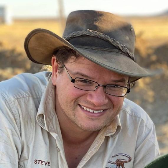 This is a close up image of scientist Stephen Poropat working in the field looking for fossils.