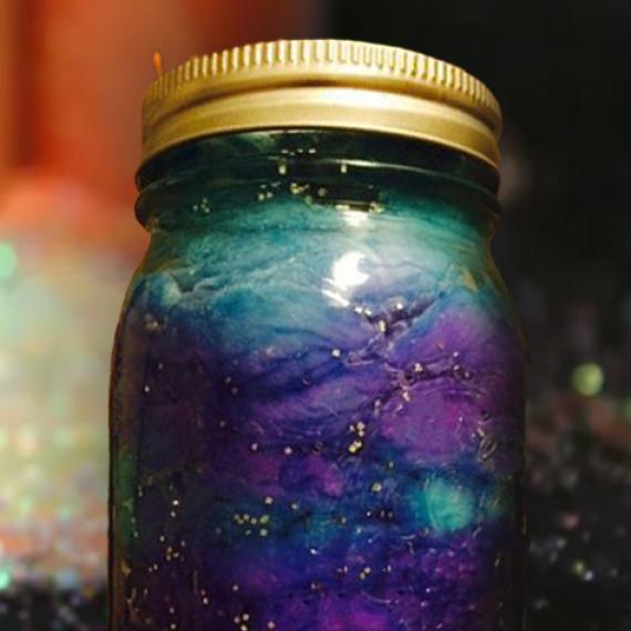 a close up of a jar with dark purples and black shiny liquid reminiscent of a space nebula