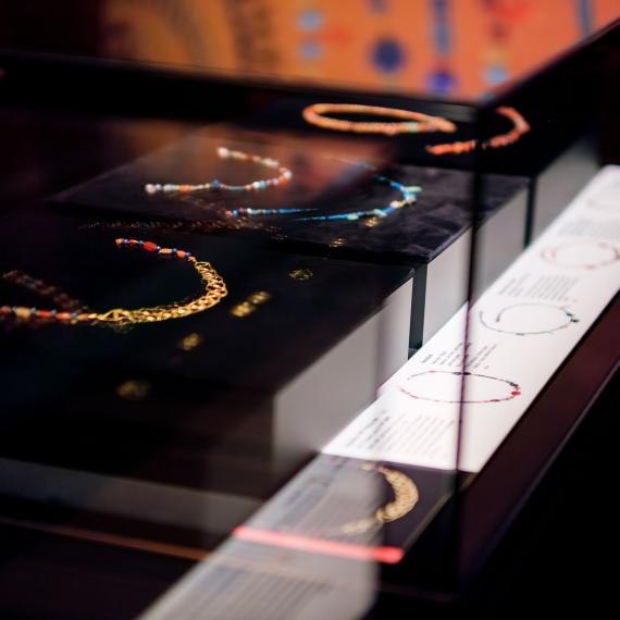 A collection of ancient Egyptian beaded jewellery on display in a Museum showcase