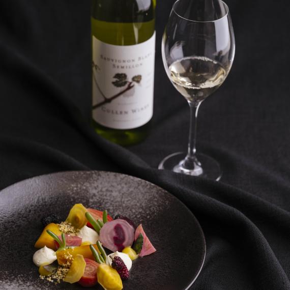 A plate of food, wine glass and wine bottle 