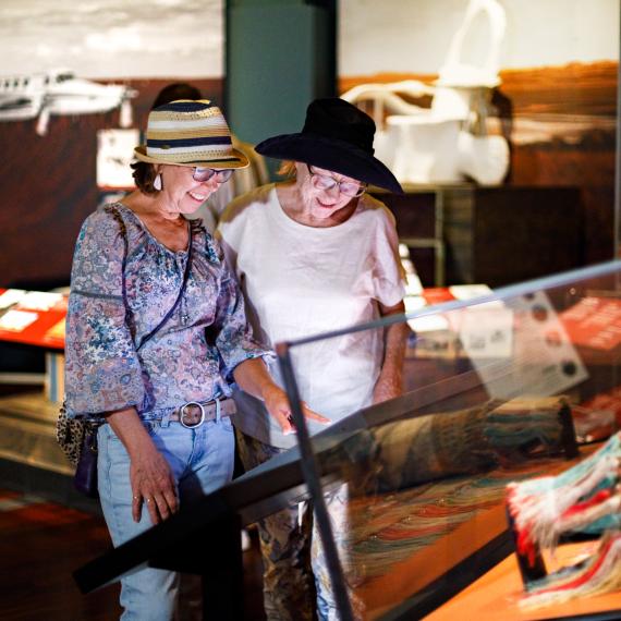 Two women examine an exhibit in a museum.