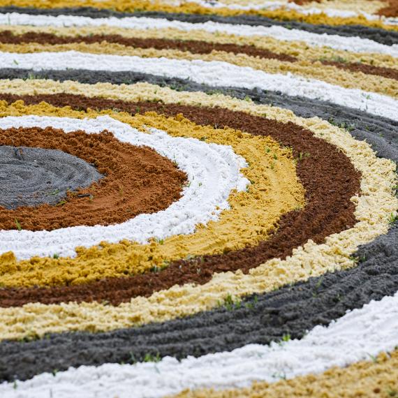 coloured sand circles making Aboriginal art