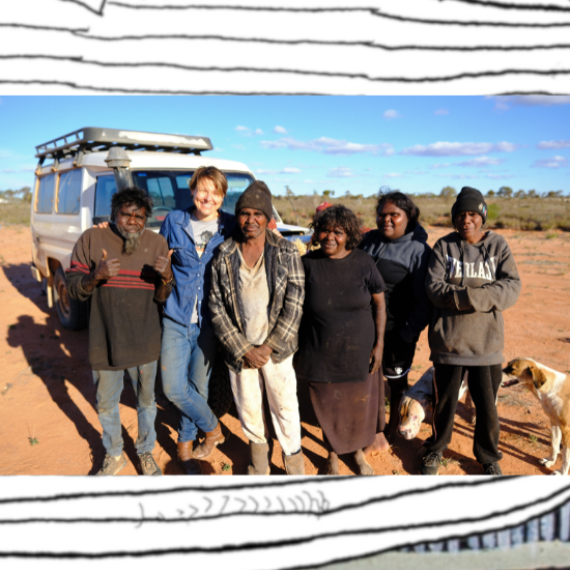 Group of six people standing in front of a car in the desert