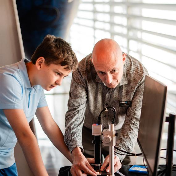 A student and WA Museum facilitator investigate marine life through a digital microscope in the WA Down Under education program.