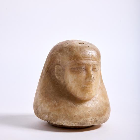 a sculpture of a human head with headdress as a jar lid sculpted from Egyptian alabaster 