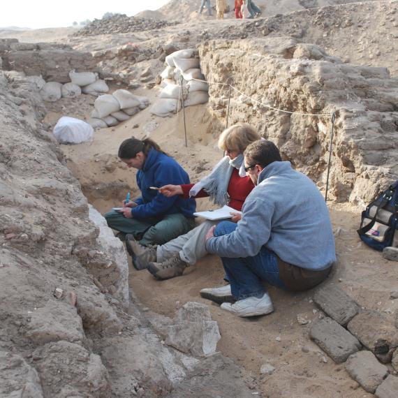 a group of people excavating a sandy tomb