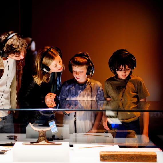 Children wearing headphones exploring an exhibition