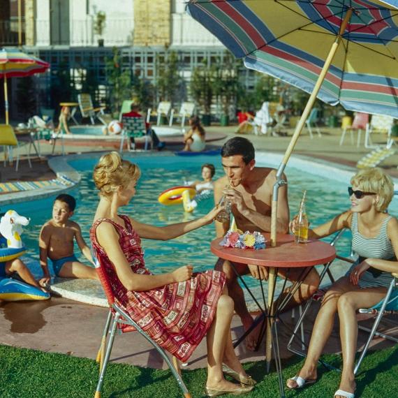 a scene of families lounging around a resort style pool 
