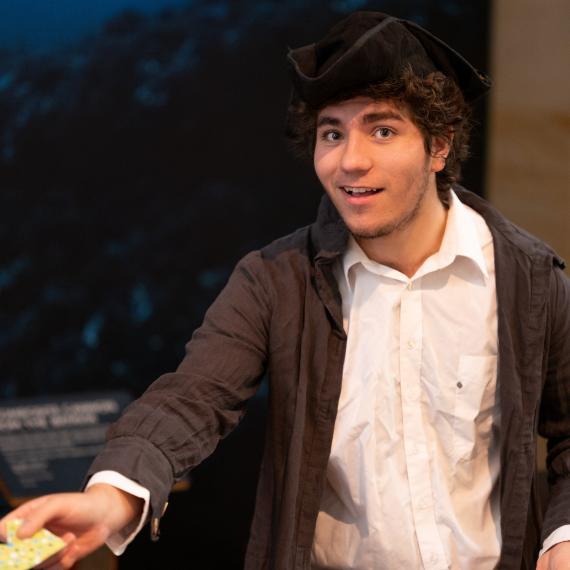 a young performer is dressed in historical clothing in the museum
