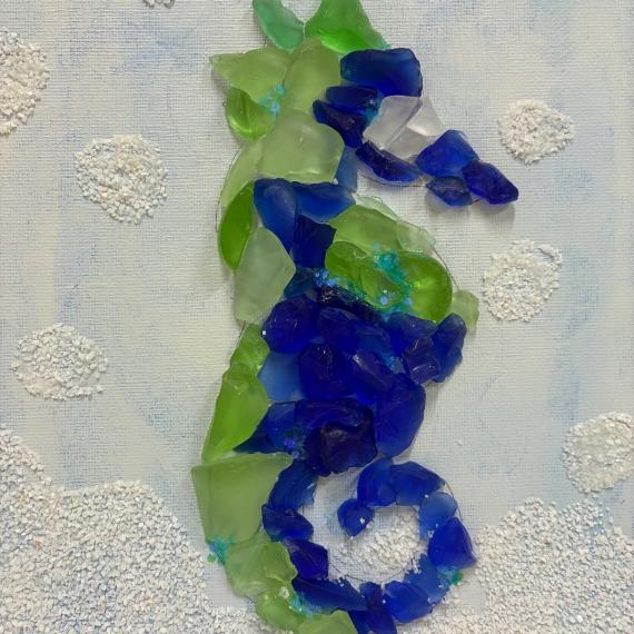 a colletion of sea glass arranged into a seahorse shape 