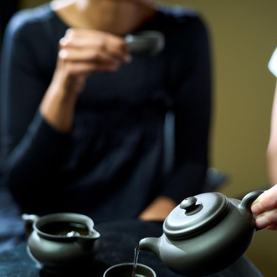 Person drinking chinese tea from tea pot