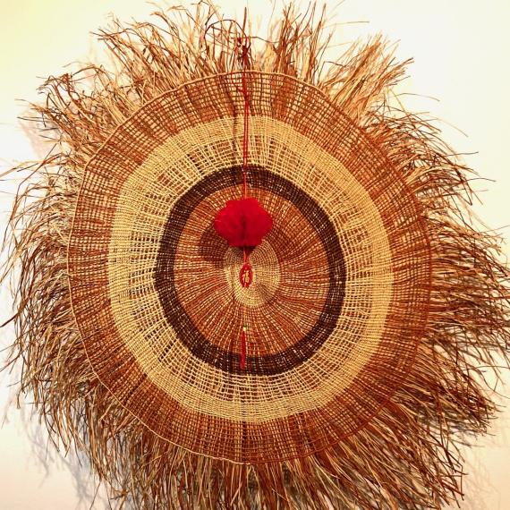 Woven artwork and Chinese lantern hanging side by side 