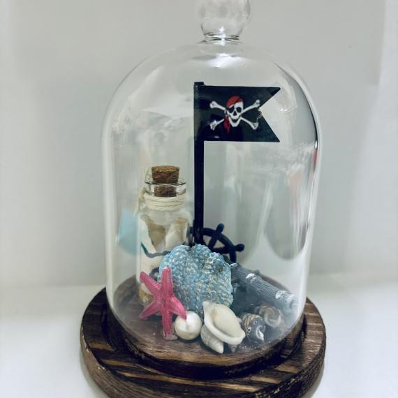 a small pirate treasure ocean scene within a mini glass cloche 
