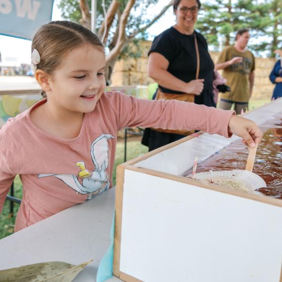 child interacting with a craft activity on a table 