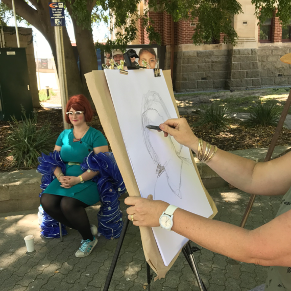  an artist drawing a portrait in an outside Venue