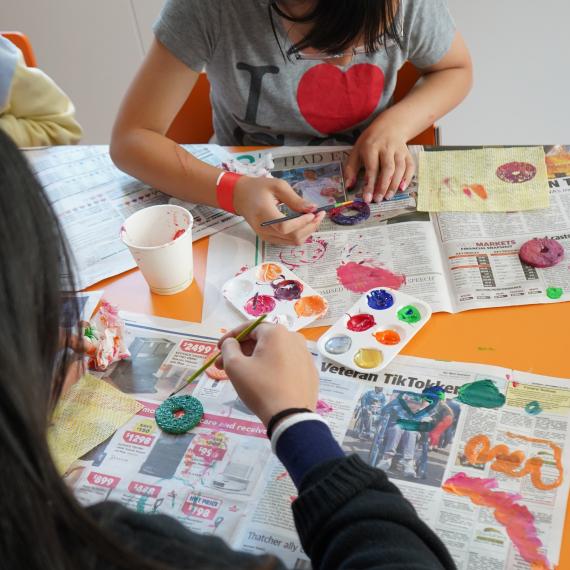 Two children painting jewellery items