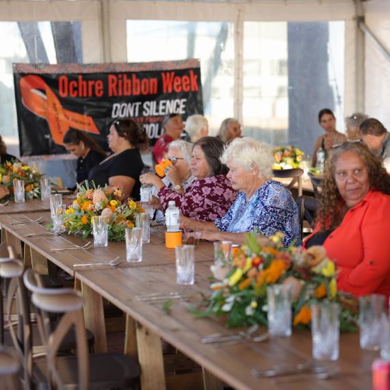 a long table decorated with floral settings and sitting at the table is many women