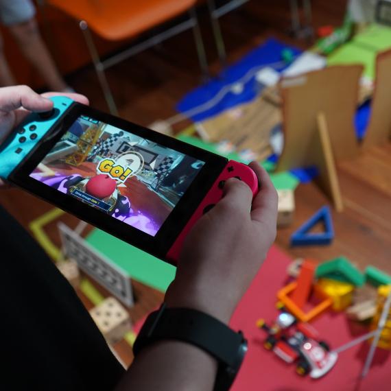 Child holding a Nintendo Switch with Mario Kart on the screen