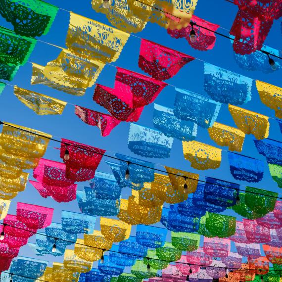 rows of different colour paper cutouts hung up outside 