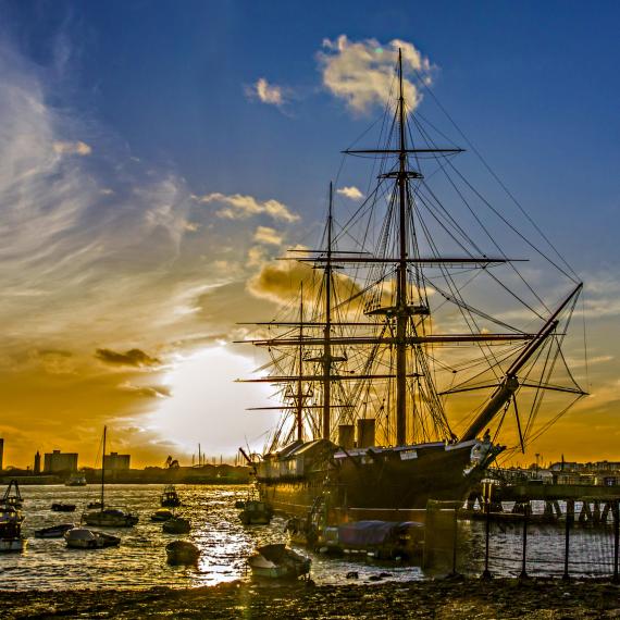 a sunset image of a ship in a marina 