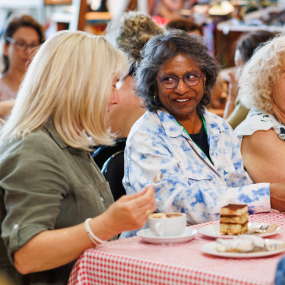 Two ladies talking enjoying a coffee and cake
