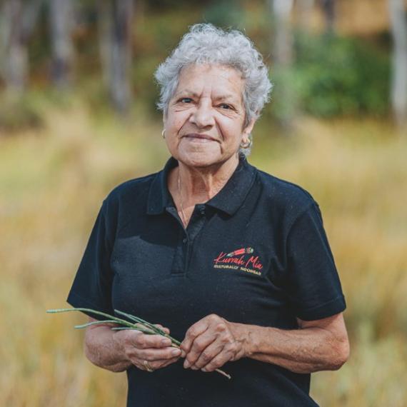 an adult person is outdoors amongst nature with a pleasant and approachable smile