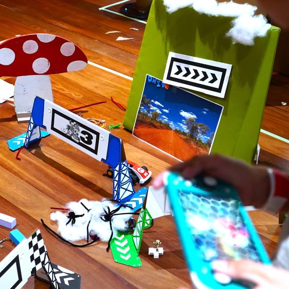 playing nintendo switch with handmade race track in the background