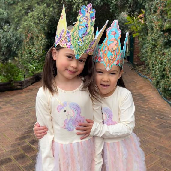 two children are wearing sea crown hats they crafted 
