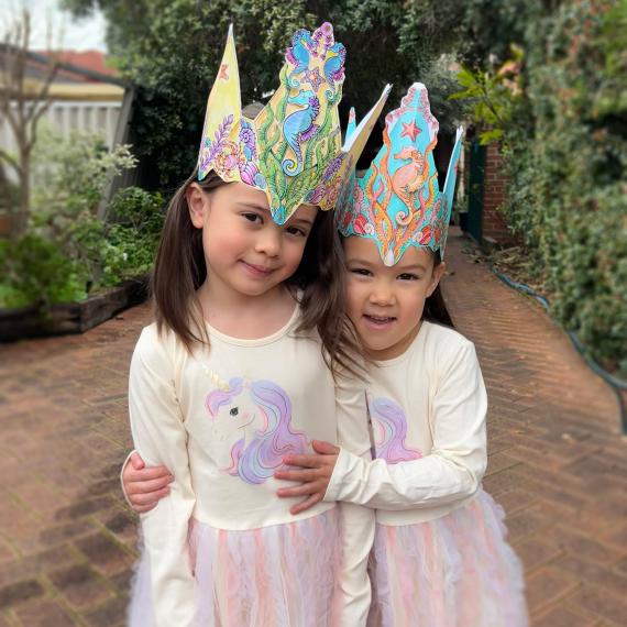 two children are wearing sea crown hats they crafted 