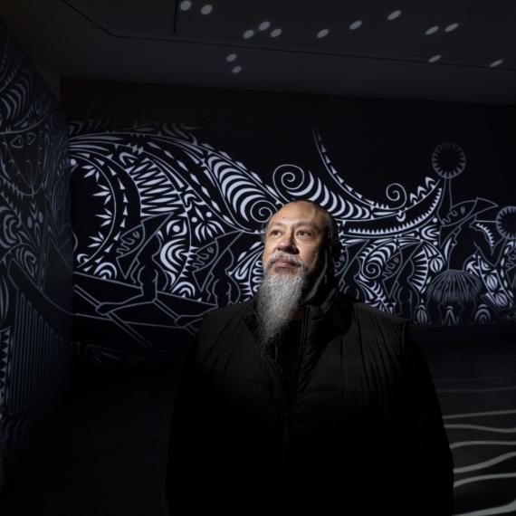 Photo of Brian Robinson in front of his artwork