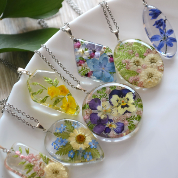 a view of a collection of six pendant resin jewellery with flowers and leaves in the art piece