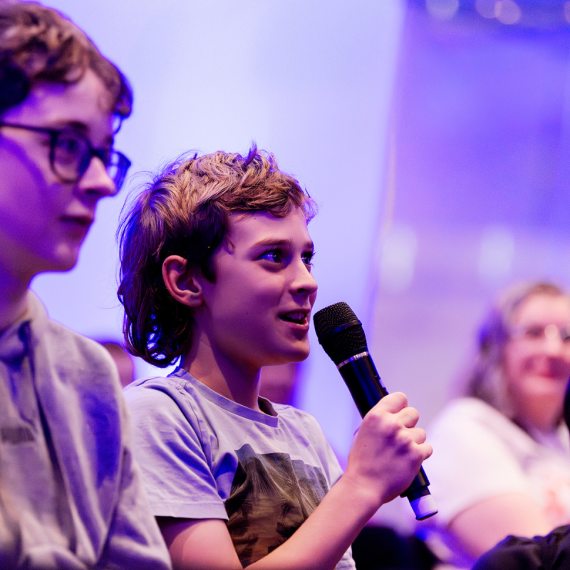 Kid holding a microphone at a talk