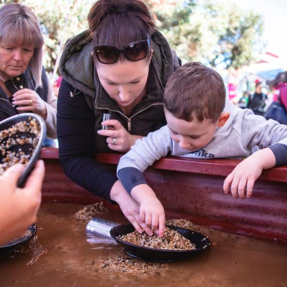 Mother and son shift through dirt to find gold