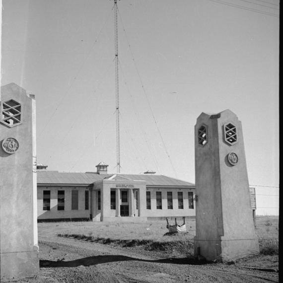 a black and white photo of a building with two pillars at the entrance 